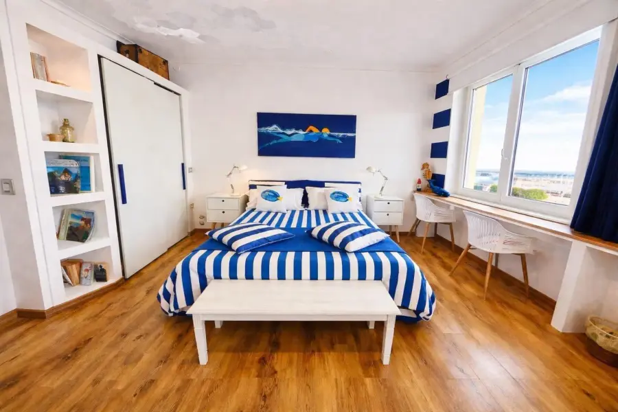 Camera Blu Vista Mare Due Finestre con letto a righe blu e bianche e due finestre
