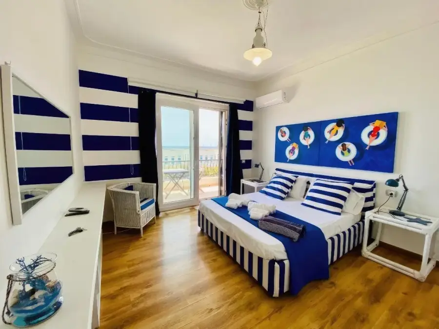 Camera Blu Vista Mare Una Finestra con letto a righe blu e bianche e finestra sul mare