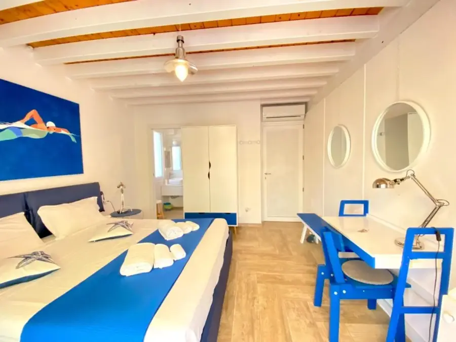 Suite Laterale con letto blu e dipinto di un nuotatore sulla parete